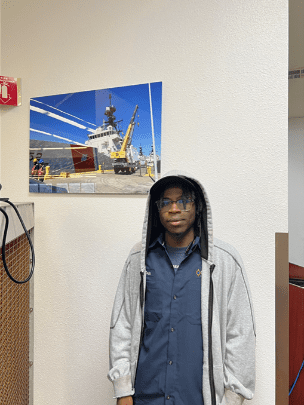 Person standing near a ship photograph.