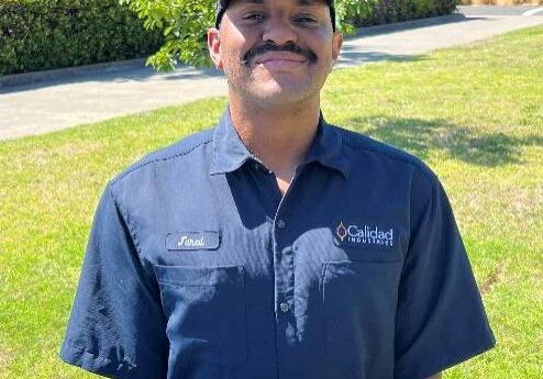 Smiling man sitting at a picnic table.