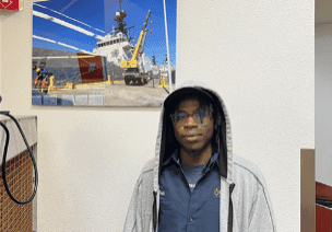 Person standing near a ship photograph.