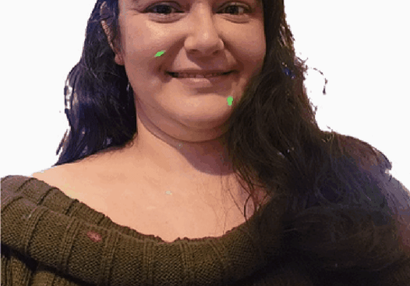 Smiling woman in brown sweater, bright background.